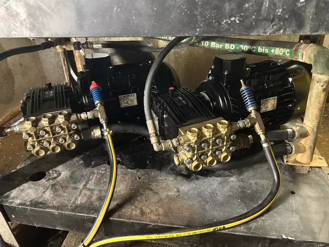 Replacement pumps and motors fitted on a multi-pump pressure washer system during repair work at a malt house in Burton.